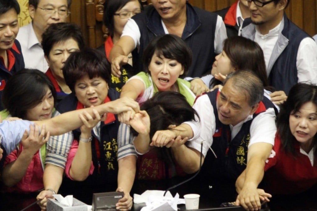 Legislators from Taiwan's ruling Kuomintang party and opposition try to seize the parliament's podium. Photo: AFP