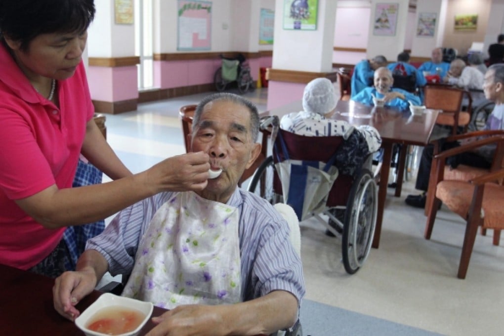 Wong Fook-chung, 86, gets a helping hand with dinner at Yee Hong Heights in Yantian, Guangdong. Photo: May Tse