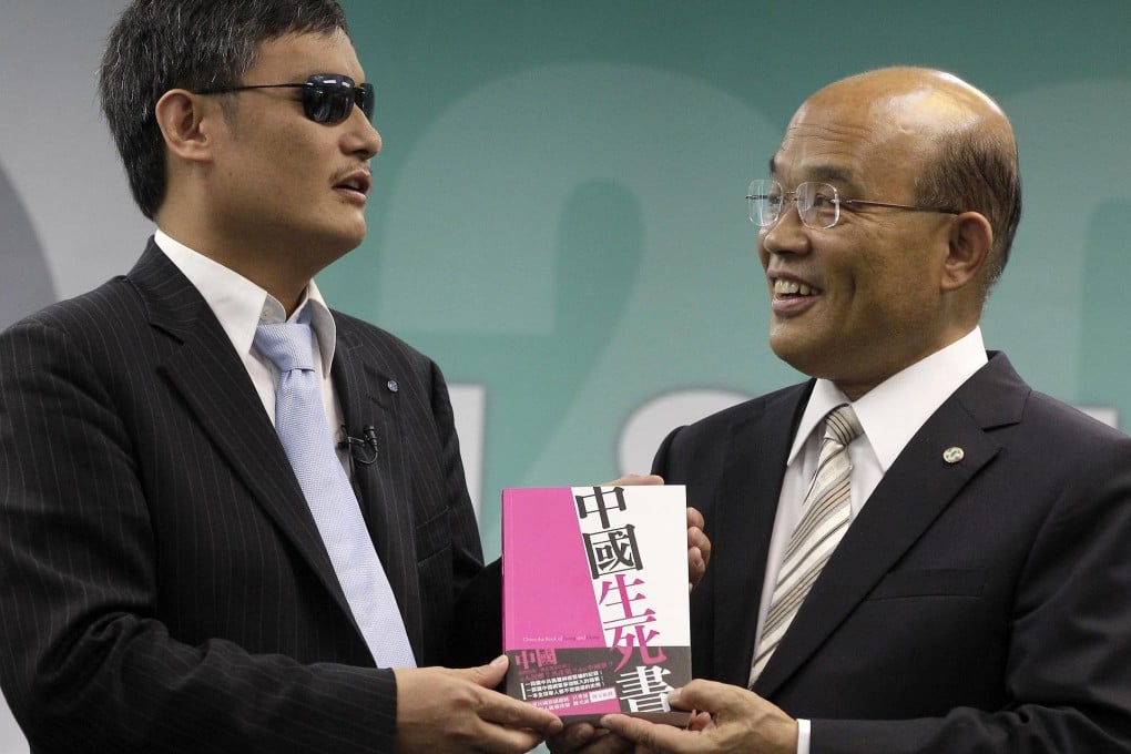 Chen Guangcheng (left) and the the DPP's Su Tseng-chang hold a new book by activists, China, the Book of Living and Dying. Photo: Reuters