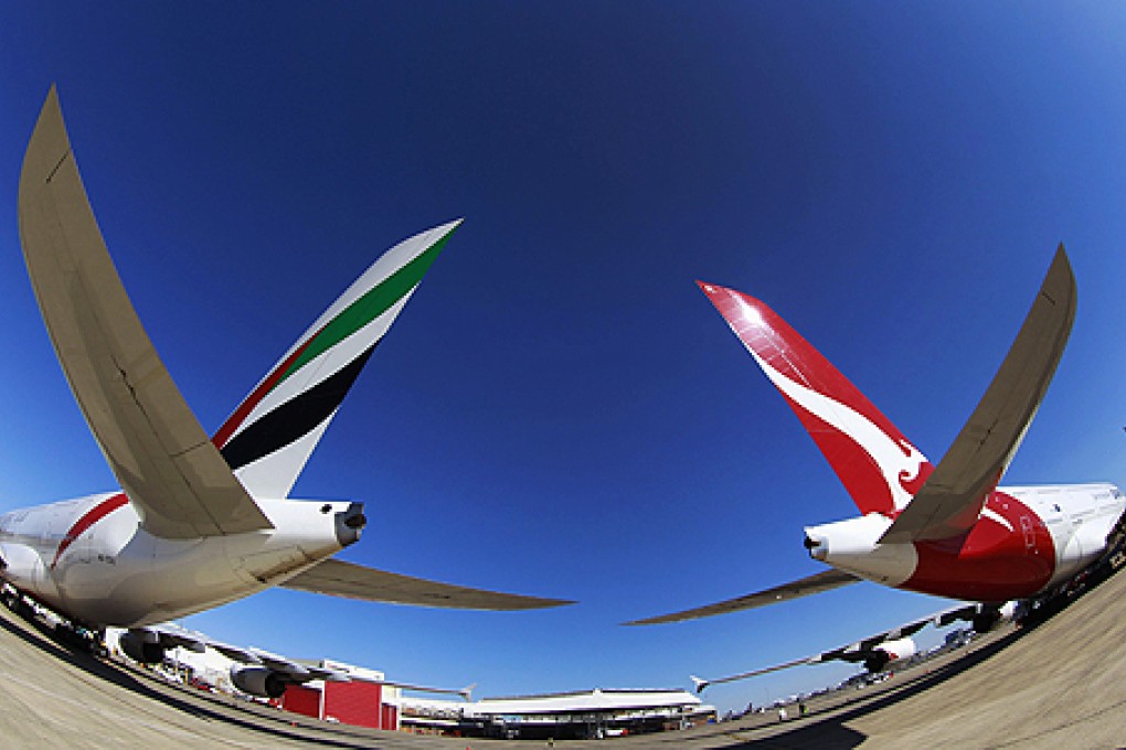 Qantas and Emirates (left) airlines were named in a report on the manufacturing of disposable economy-class earphones. Photo: Reuters