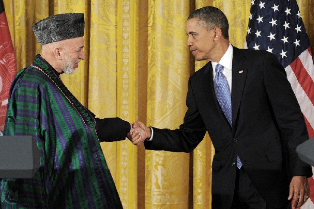 US President Barack Obama shakes hands with Afghan President Hamid Karzai. Photo: AFP
