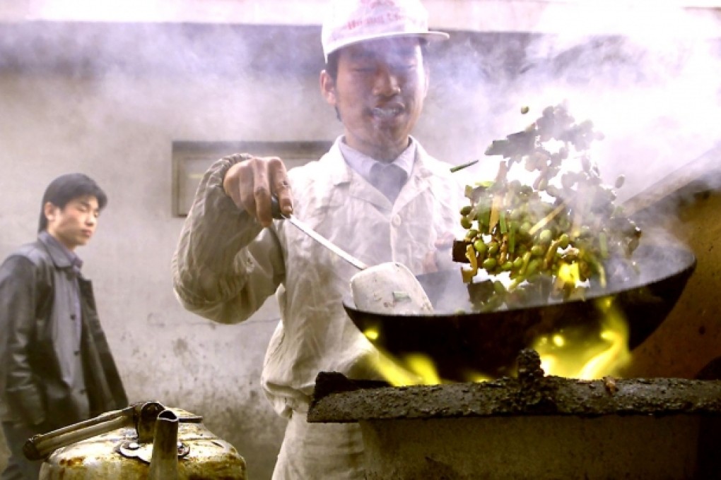 A sidewalk chef stir-fries a bunch of vegetables in his blazing wok in downtown Beijing. Chinese officials are increasingly concerned about the widespread use of recycled oil. Photo: AFP