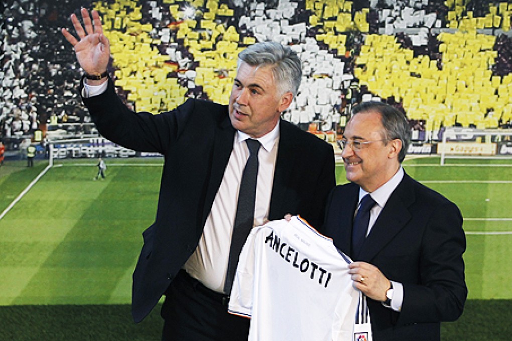 Carlo Ancelotti waves to the fans as Real Madrid's President Florentino Perez displays a shirt with his name. Photo: AP