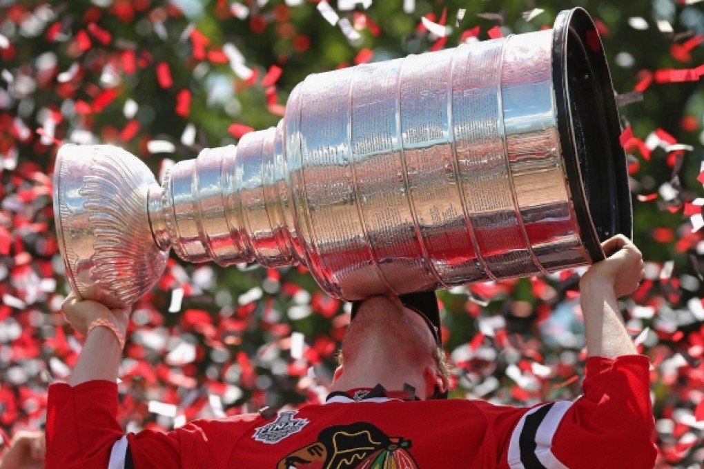 Bryan Bickell of the Chicago Blackhawks kisses the Stanley Cup trophy during the victory parade through the city. Photo: AFP