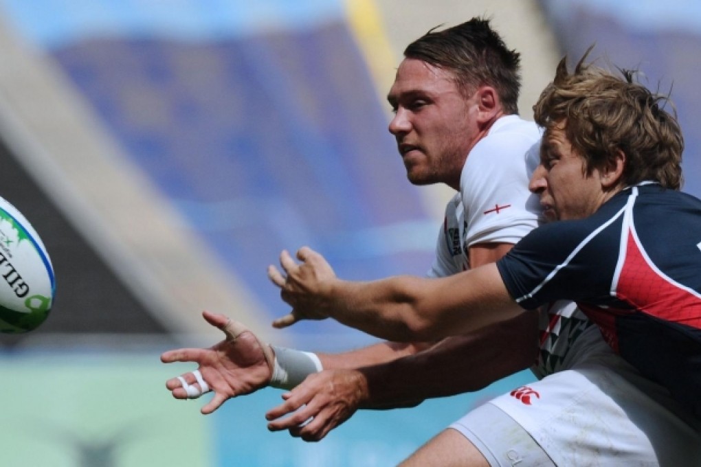England's Christian Lewis-Pratt vies with Tom McQueen of Hong Kong during their group stage match yesterday. Photo: AFP