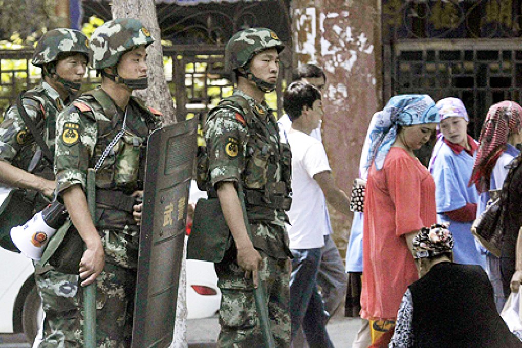 Armed police officers stand guard near the bazaar in Urumqi on Saturday. Photo: Reuters