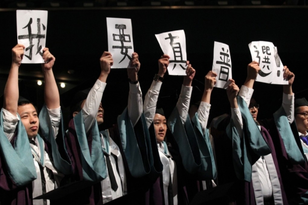Students from the Academy for Performing Arts hold placards that say "I want genuine universal suffrage". Photo: SCMP
