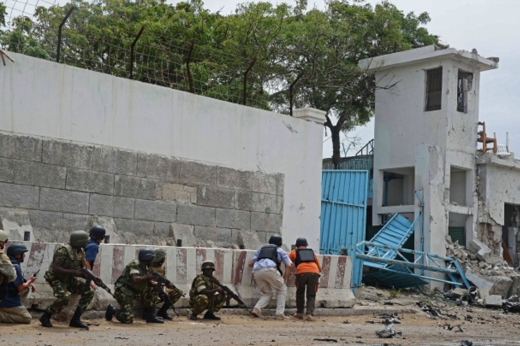 Amisom troops take cover after al-Qaeda linked al-Shabab insurgents blasted their way into the UN compound in Mogadishu on June 19. Photo: AFP