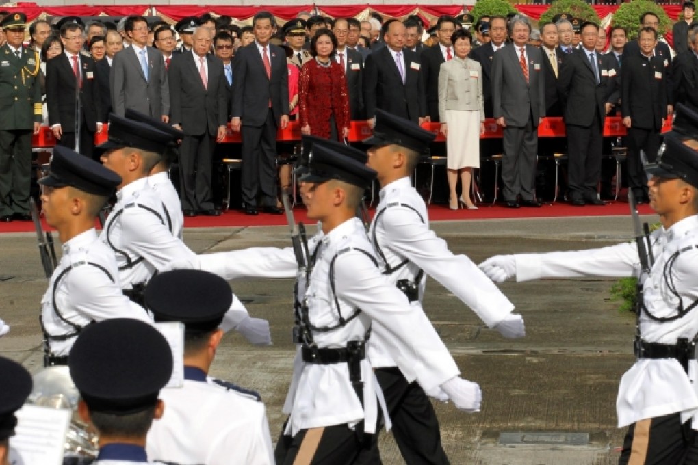 The city's top brass stand as police officers march past at the Golden Bauhinia Square flag-raising ceremony. Photo: Edward Wong