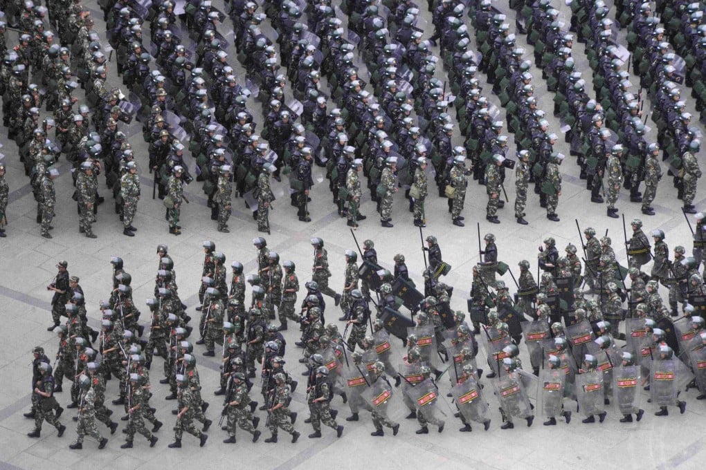 Armed paramilitary policemen run in formation during a gathering to mobilize security operations in Urumqi, June 29, 2013. Photo: Reuters