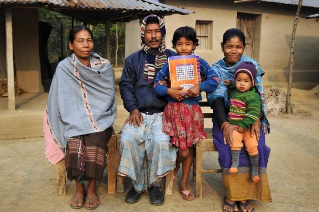 Orola Dalbot (with child on lap) and her husband, Noten (centre), who is also married to Orola's mother (left).
