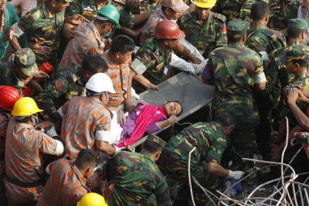 Rescuers lift garment worker Reshma from the rubble. Photo: AFP