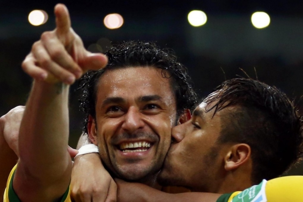 Brazil hero Fred gets a celebratory kiss from Neymar after scoring one of his two goals in the 3-0 victory over Spain. Photo: Reuters