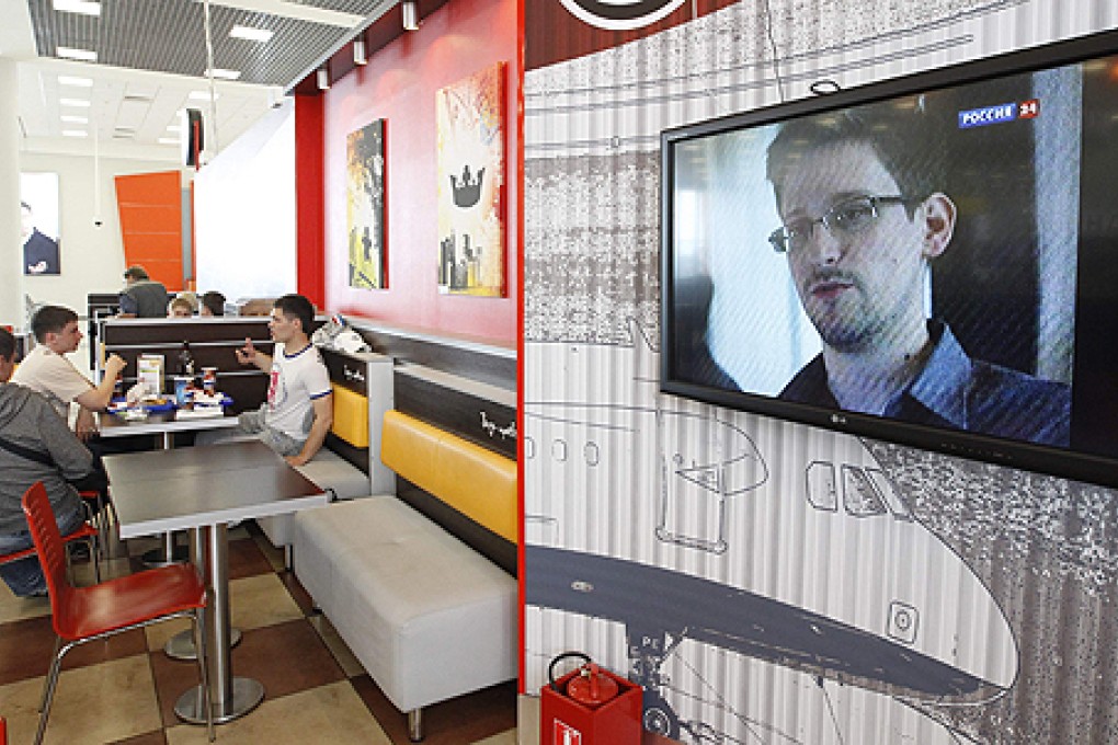 A television screen shows Edward Snowden during a news bulletin at a cafe at Moscow's Sheremetyevo airport. Photo: Reuters