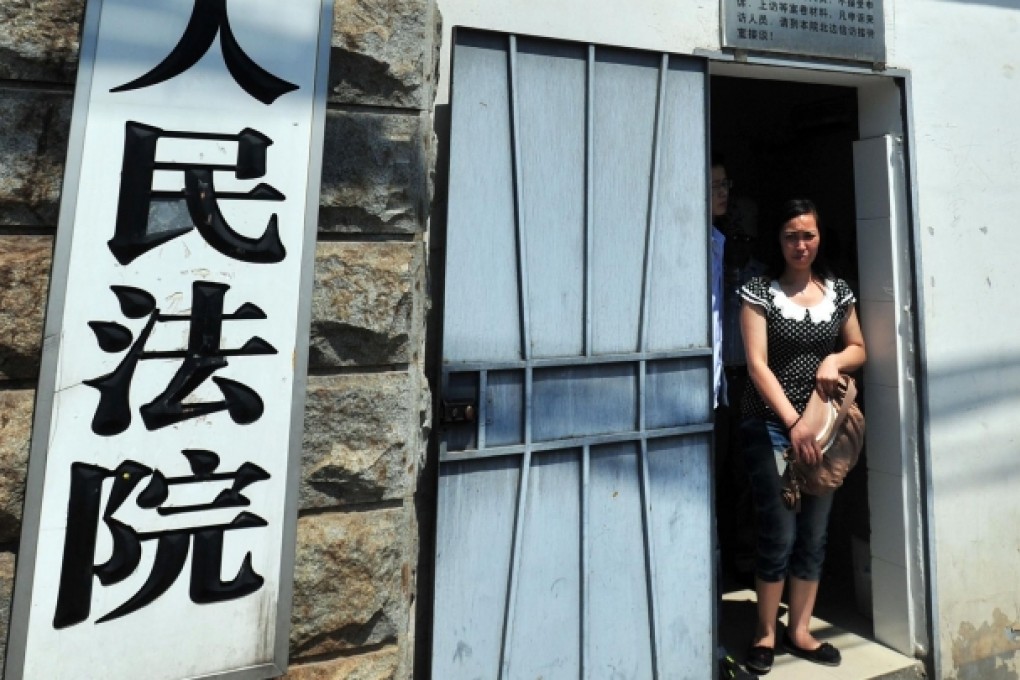 This picture taken on July 1, 2013 shows Tang Hui, a mother of a young rape victim, standing in the reception room of the Hunan provincial high court in Changsha, central China's Hunan province. Photo: AFP