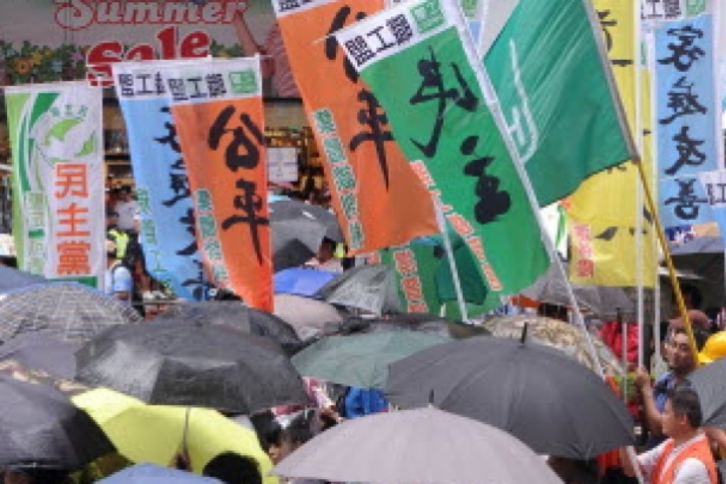 Protesters with slogans demanding democracy and fairness in this year's July 1 march. Photo: AFP