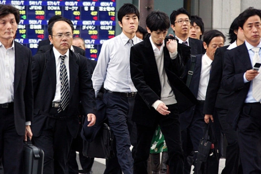 Office workers cross a street in Tokyo. Photo: AP