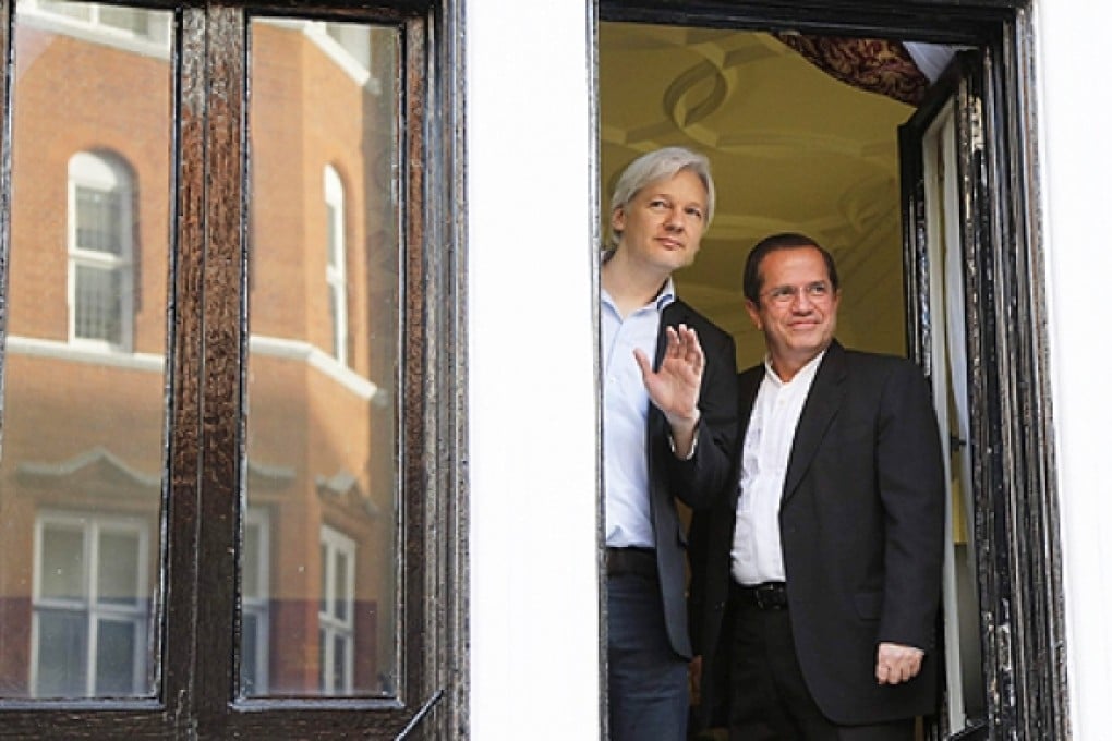WikiLeaks founder Julian Assange waves from a window with Ecuador's Foreign Affairs Minister Ricardo Patino (right) at Ecuador's embassy in central London on June 16. Photo: Reuters