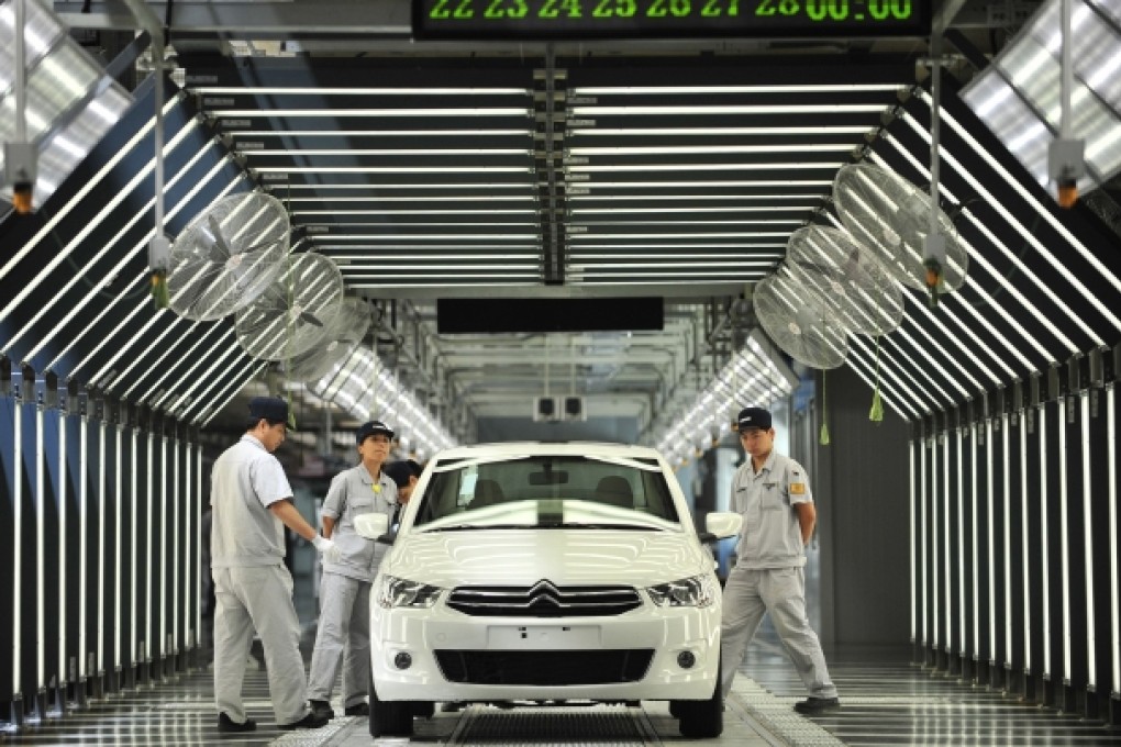 Employees on the production line in a new plant of Dongfeng Peugeot-Citroën Automobile Ltd. in Wuhan, central China's Hubei province, July 2, 2013. Photo: AFP