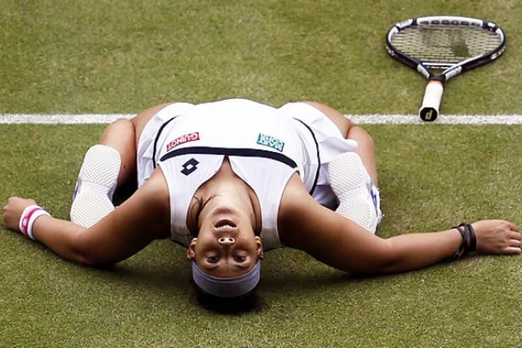 Marion Bartoli falls to the grass as she celebrates beating Kirsten Flipkens to reach her second Wimbledon final. Photo: AFP