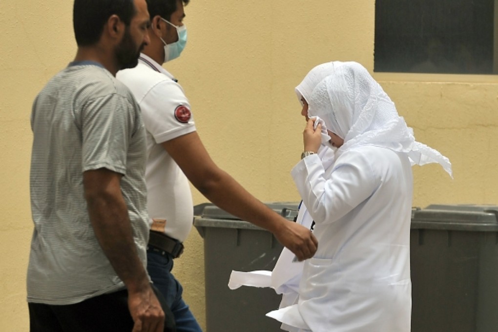 Saudi nurses and citizens walk outside the King Fahad hospital in Hofuf, Saudi Arabia. Photo: AFP