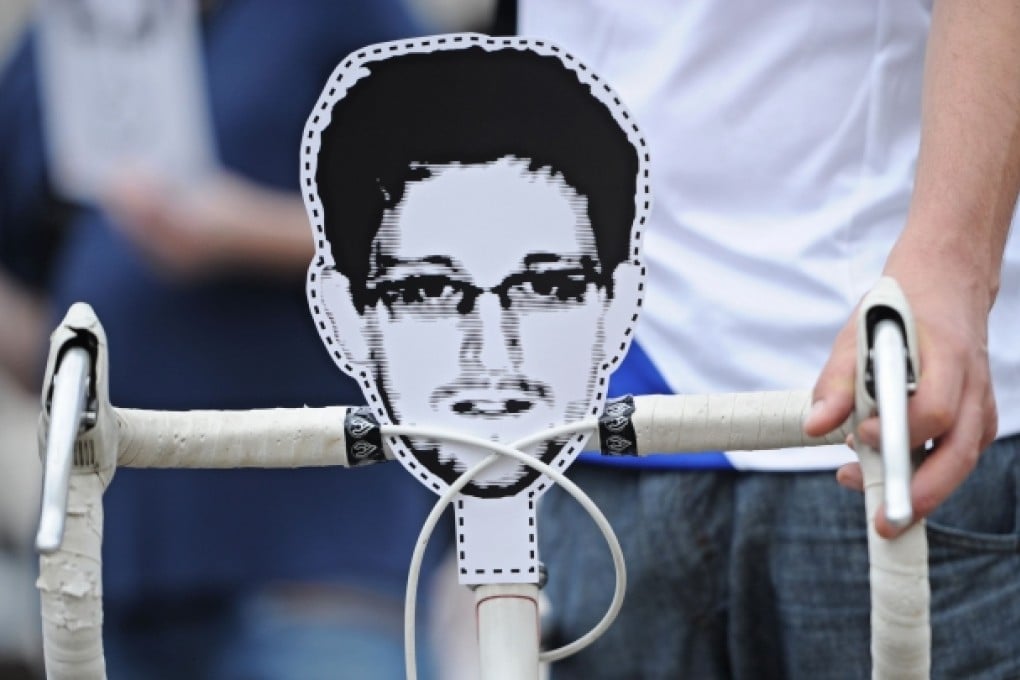 Demonstrators stand in front of the Brandenburg Gate and show their support for Edward Snowden in Berlin. Photo: AFP