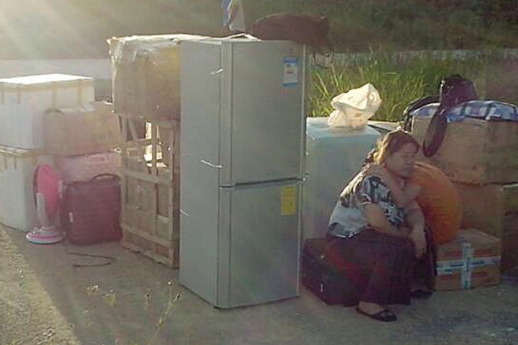 Ye Haiyan and her daughter sit with their possessions by a road in Taishan, where they say police abandoned them. Photo: SMP