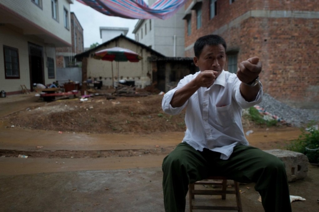 Former miner Zeng Guangqiang, now back in Shanglin, shows how miners in Ghana are regularly robbed at gunpoint. Photo: AFP