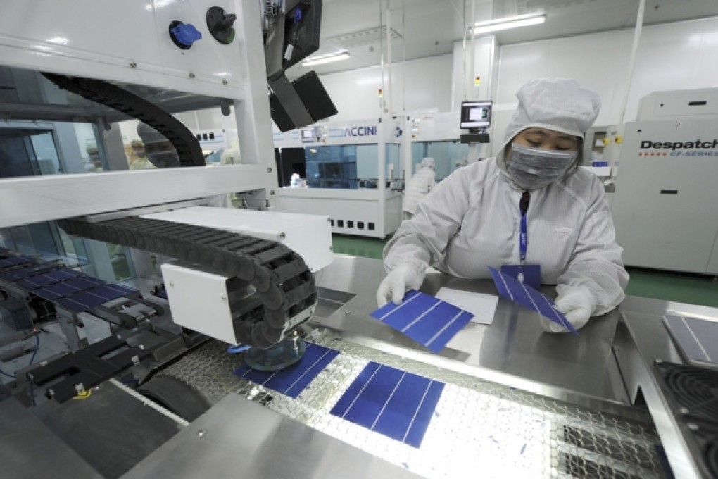 An employee inspects solar panels along a production line at an LDK workshop. Photo: Reuters