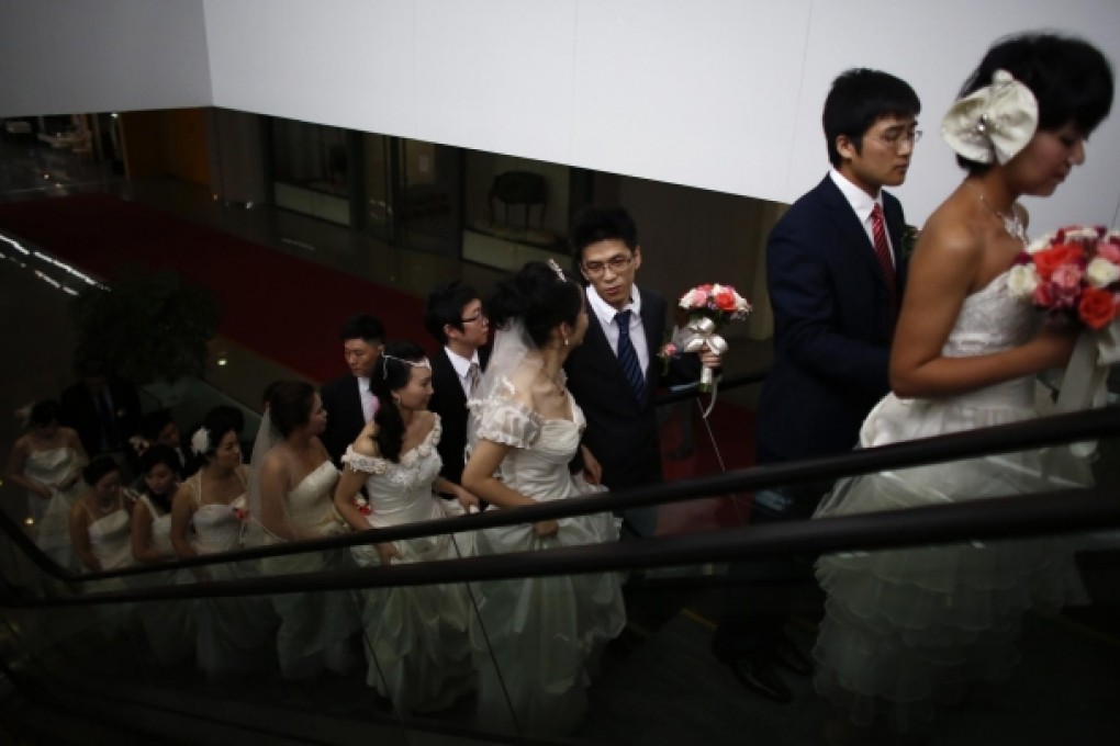 Couples at a mass wedding at a matchmaking event in Shanghai in May. Women may be best off with younger husbands. Photo: Reuters