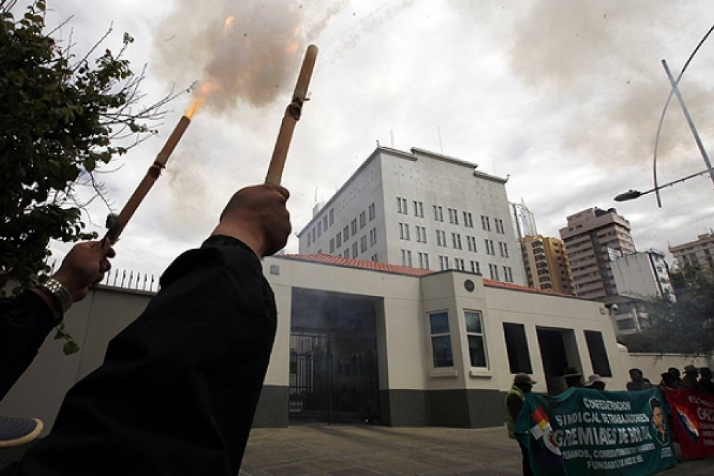 Demonstrator launch firecrackers outside the US embassy during a protest in La Paz. Photo: AP