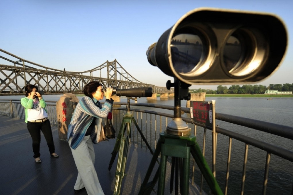 Chinese tourists look across to North Korea at Dandong. Photo: AFP