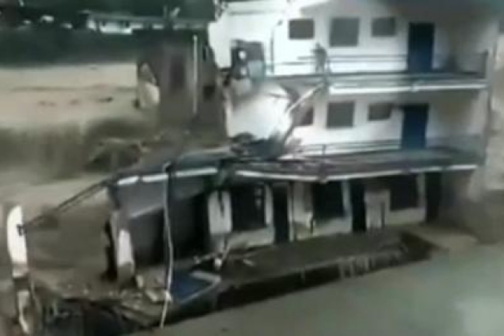 Floods rage around a man trapped in a damaged house in Sichuan. Photo: SCMP Pictures