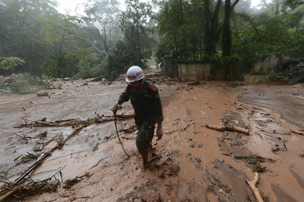 A firefighter walks across the floodwaters amid heavy rainfalls after a rain-triggered landslide hit Zhongxing county of Dujiangyan in Sichuan. Photo: Reuters