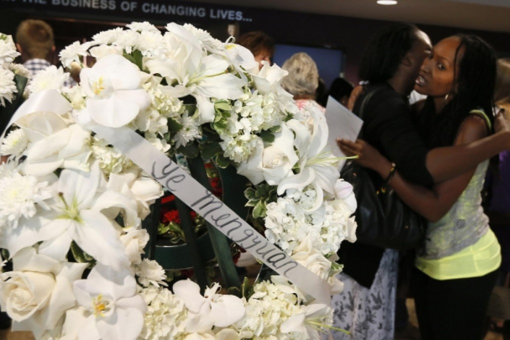 Mourners embrace near a wreath carrying the name of Ye Mengyuan at the West Valley Christian service. Photo: Reuters