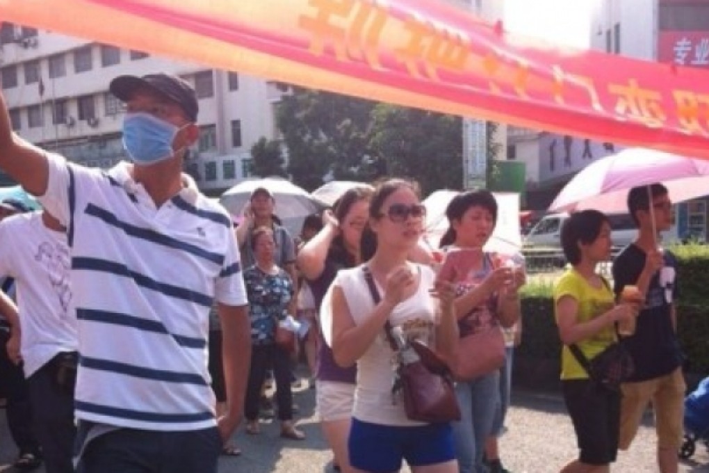 Demonstrators hold banners against a uranium processing facility in Jiangmen on Friday. Photo shared by local resident.