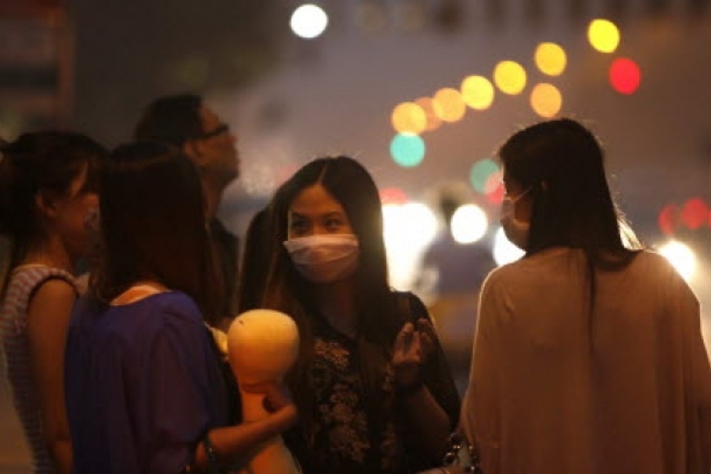 Pedestrians wear masks as smog engulfs Beijing. Photo: EPA