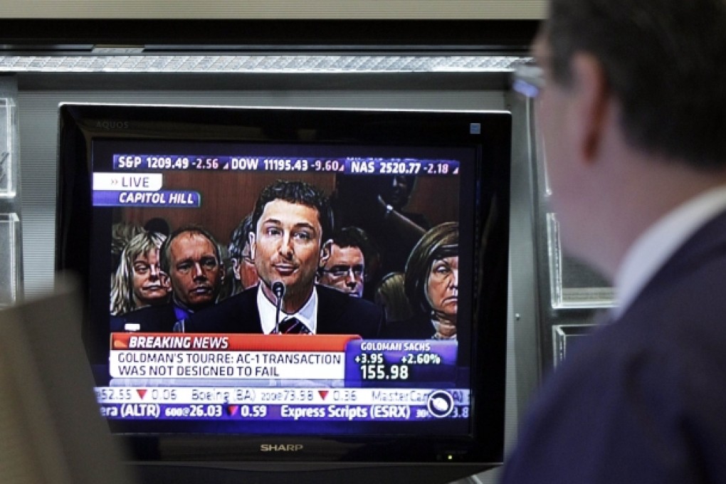 A trader watches televised coverage of testimony by Fabrice Tourre before a Senate panel. Photo: AP