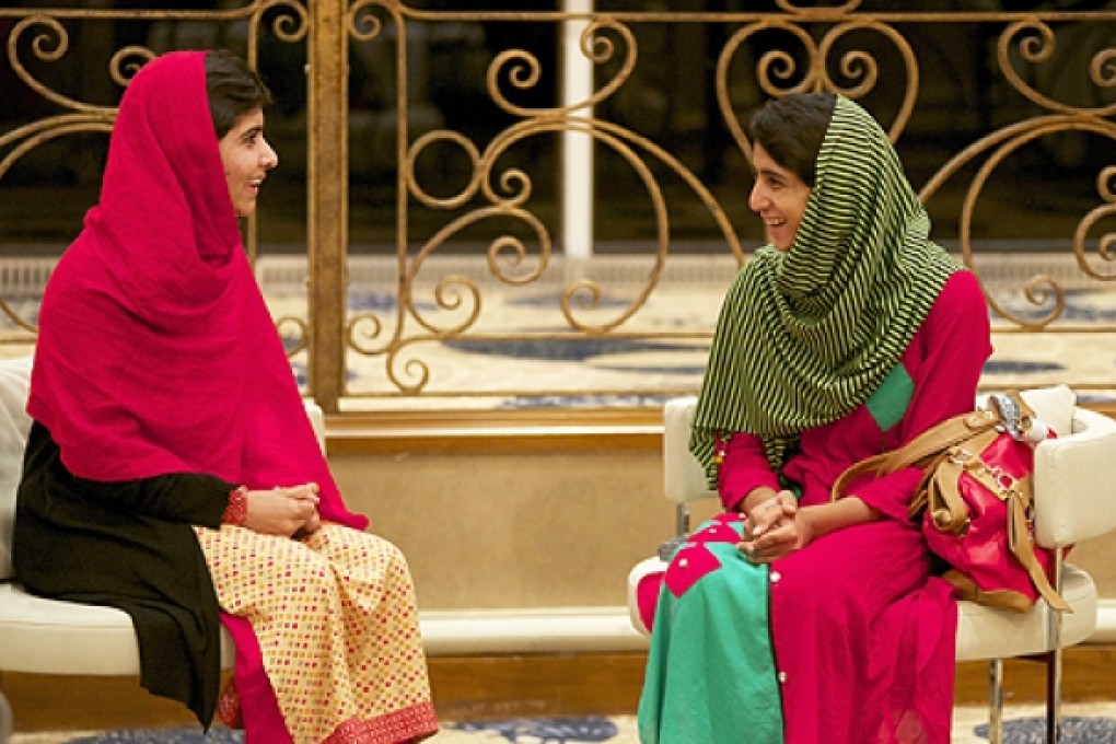 Malala Yousafzai (left) chats to schoolfriend Shazia Ramzan after being reunited at Birmingham airport, central England, on June 29. Photo: EPA