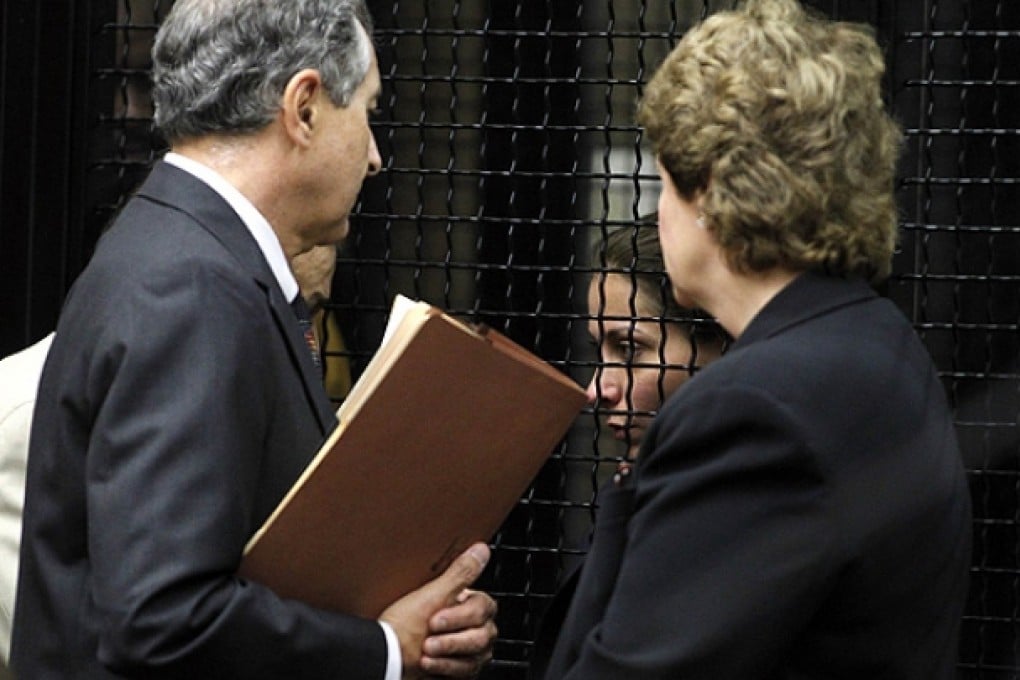 Saudi Arabian princess Alayban, behind bars, listens to advice from defence attorneys in Santa Ana. Photo: Reuters