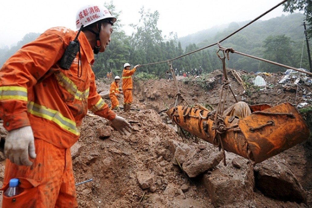 Rescue workers remove a body recovered from a landslide in Sanxi village. Photo: AP