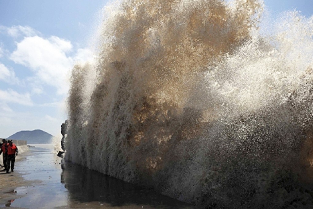 Frontier soldiers look at the swell, as they carry out a check of a seawall, as Typhoon Soulik approaches in Wenling, Zhejiang province on Friday. Photo: Reuters