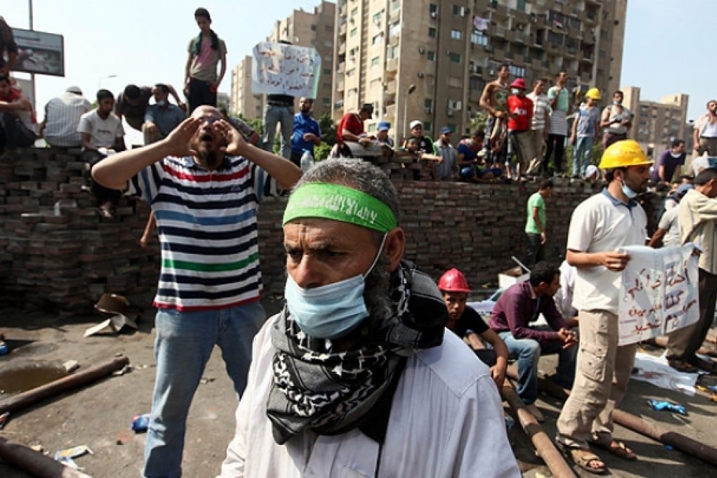 Muslim Brotherhood members gather behind makeshift road blocks in Cairo. Photo: EPA