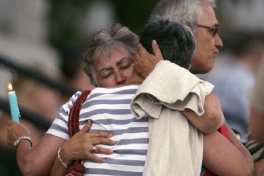 A woman consoles her friend during a vigil at Sainte-Agnes church in Lac-Megantic in Quebec. Transportation workers searched the site of the train derailment as police increased the number of confirmed killed by four to 28. Photo: Reuters