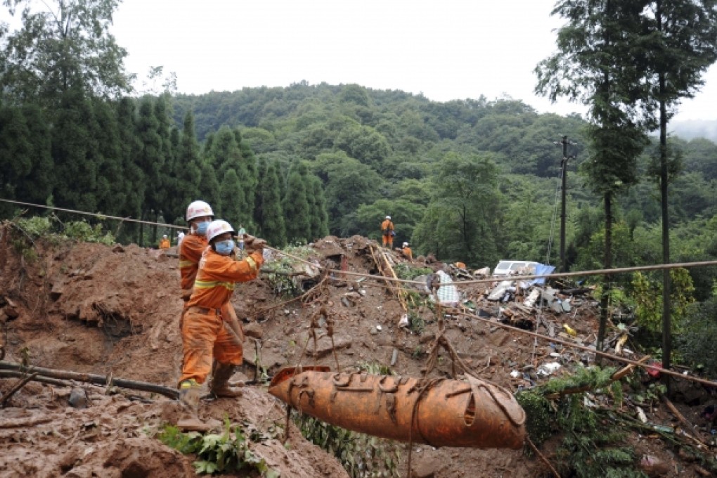Rescue workers remove bodies from the site of landslide that killed dozens in Dujiangyan, Sichuan. Photo: AP