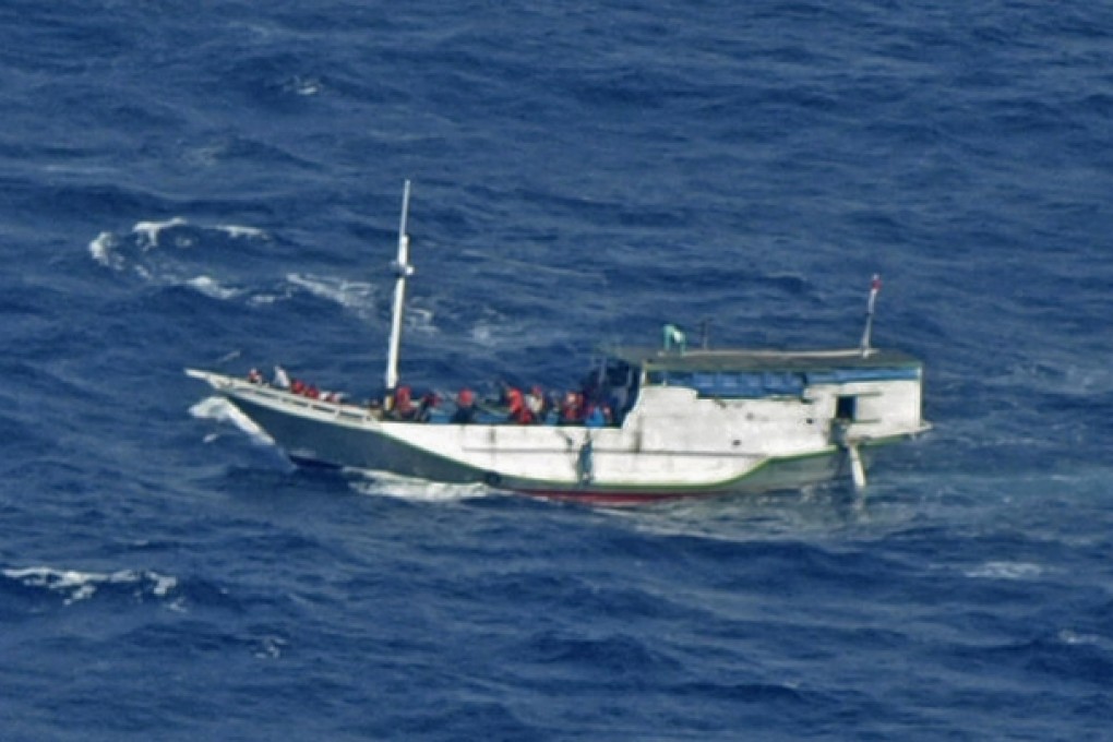 A rickety wooden boat approaches Christmas Island from Indonesia with about 180 asylum seekers aboard in July last year. Photo: AP
