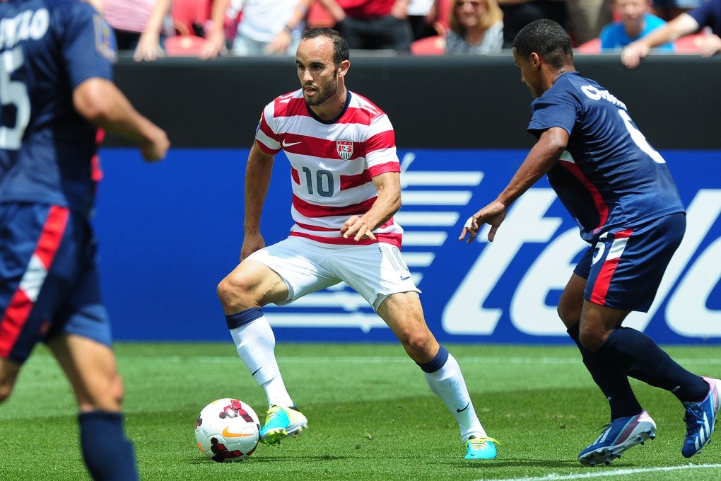 Landon Donovan (centre) of the US looks for a clean pass under pressure from Cuba's Yoel Colome (right) during their Gold Cup match in Sandy, Utah on Saturday. Photo: AFP