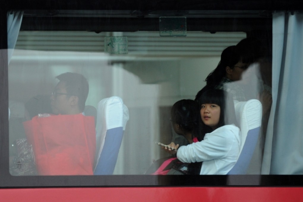Students and teachers of Jiangshan Middle School are seen on a bus at Capital International Airport in Beijing as they returned to China on Saturday. Photo: Xinhua