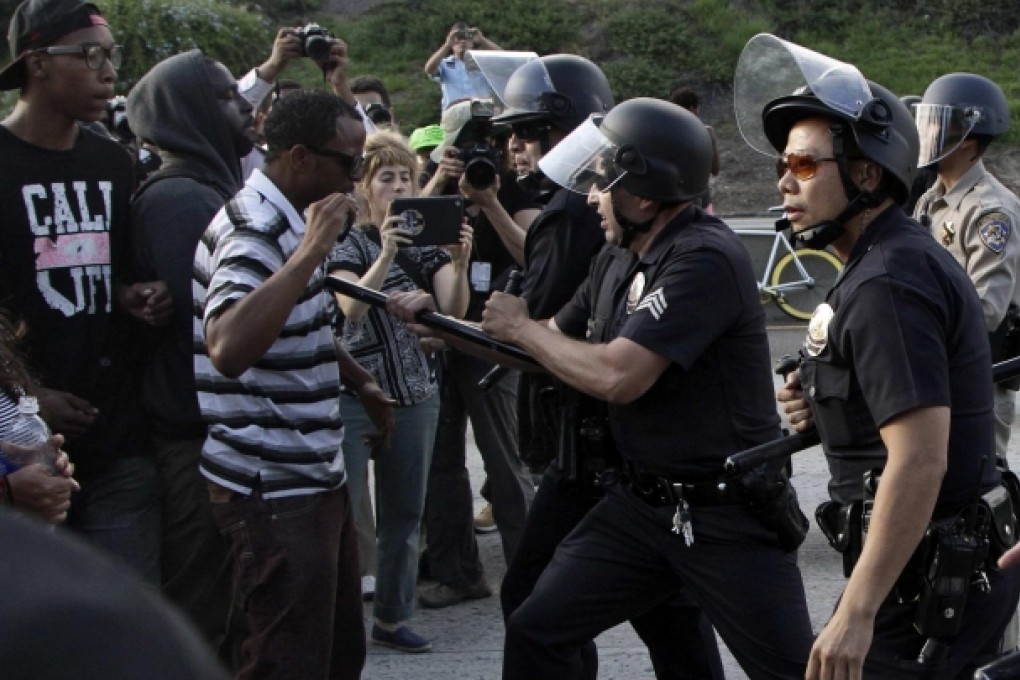 Police confront demonstrators trying to block traffic on a freeway in Los Angeles on Sunday in protest against the verdict. Photo: Reuters