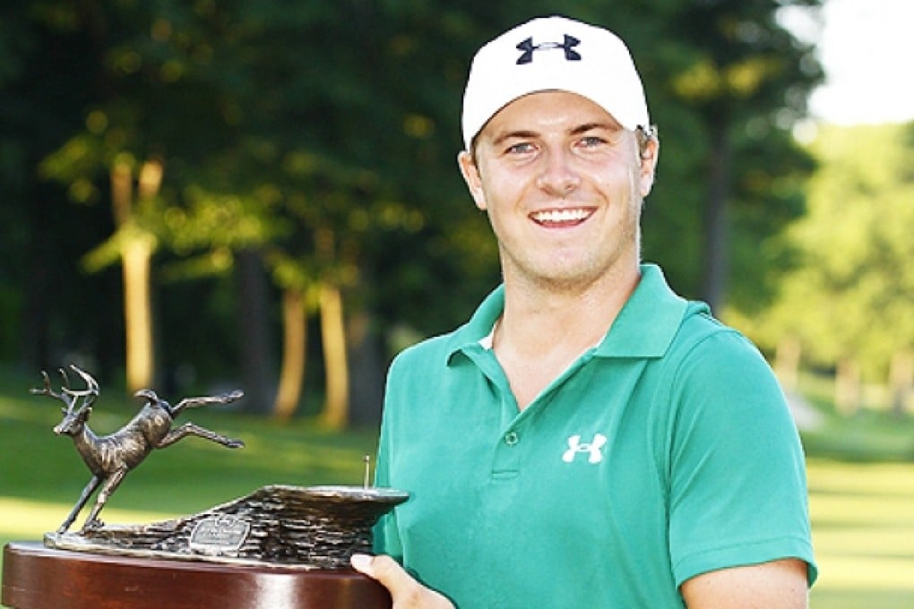 Jordan Spieth holds the trophy after winning a three way five hole sudden death playoff after the final round of the John Deere Classic held at TPC Deere Run on Sunday in Silvis, Illinois. Photo: AFP